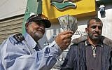A Palestinian man shows his money after receiving his salary in Rafah in the southern Gaza Strip November 9, 2018. (Said Khatib/AFP)