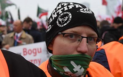 Supporter of the far-right movement Oboz Narodowo Radykalny (National Radical Camp) wearing a cape reading 'Anti-Antifa. Good night left side' attends the 'March of Independence,' on November 11, 2018, in Warsaw to mark 100 years of Polish independence. (Janek SKARZYNSKI / AFP)