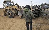 A member of Hamas' Al-Qassam Brigades stands next to the remains of a car that was destroyed following an Israeli airstrike, in Khan Younis in the southern Gaza Strip on November 12, 2018. (SAID KHATIB / AFP)