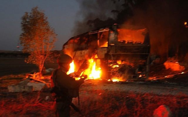 Israeli security forces and firefighters gather near a bus set ablaze after it was hit by an anti-tank missile fired from the Palestinian enclave, at the Israel-Gaza border near the kibbutz of Kfar Aza, on November 12, 2018. (Menahem KAHANA / AFP) Israeli security forces and firefighters gather near a bus set ablaze after it was hit by an anti-tank missile fired from the Palestinian enclave, at the Israel-Gaza border near the kibbutz of Kfar Aza, on November 12, 2018. (Menahem KAHANA / AFP)