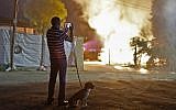 A man watches a building that was set ablaze after it was hit by a rocket fired from the Gaza Strip, in the southern Israeli town of Sderot on November 12, 2018. (Menahem KAHANA / AFP)