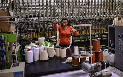 A woman works at a silk fabric factory in the Greek northern town of Soufli on October 10, 2018. (Photo by ARIS MESSINIS / AFP)