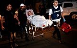 A wounded Israeli woman is evacuated from her apartment, which was set ablaze by a rocket fired from the Gaza Strip, in the southern Israeli city of Ashkelon on November 12, 2018. (Gil Cohen-Magen/AFP)