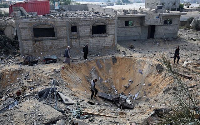Palestinians inspect a crater caused by an Israeli airstrike earlier this week during fighting with Palestinian terror groups, in Rafah in the southern Gaza Strip, on November 14, 2018. (Said Khatib/AFP) Palestinians inspect a crater caused by an Israeli airstrike earlier this week during fighting with Palestinian terror groups, in Rafah in the southern Gaza Strip, on November 14, 2018. (Said Khatib/AFP)