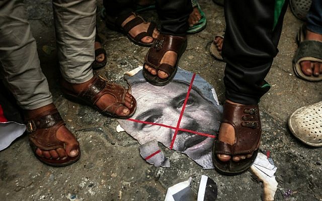 Palestinians step on a burnt image of Defense Minister Avigdor Lieberman in front of the house Hamas chief Ismail Haniyeh's home in Gaza on November 14, 2018. (Mahmud Hams/AFP)