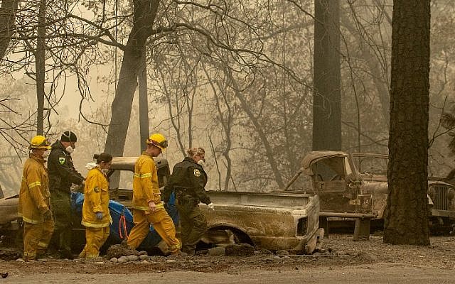 Rescue workers carry a body away from a burned property in the Holly Hills area of Paradise, California on November 14, 2018. (Josh Edelson / AFP) Rescue workers carry a body away from a burned property in the Holly Hills area of Paradise, California on November 14, 2018. (Josh Edelson / AFP)