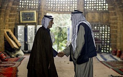 Members of an Iraqi clan shake hands as they meet inside a straw tent in the town of Mishkhab, south of Najaf on November 15, 2018. (Haidar Hamdani/AFP)