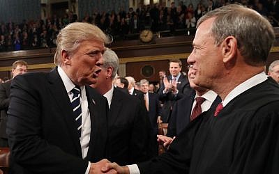 In this file photo taken on February 28, 2017, US President Donald Trump, left, shakes hands with US Supreme Court Chief Justice John Roberts as Trump arrives to deliver his first address to a joint session of Congress in Washington, DC. ( JIM LO SCALZO / POOL / AFP)