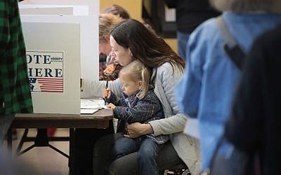 Emily Kadel votes whilie holding her two-year-old daughter Lydia at a polling place on November 6, 2018 in Kirkwood, Missouri. (Scott Olson/Getty Images/AFP)