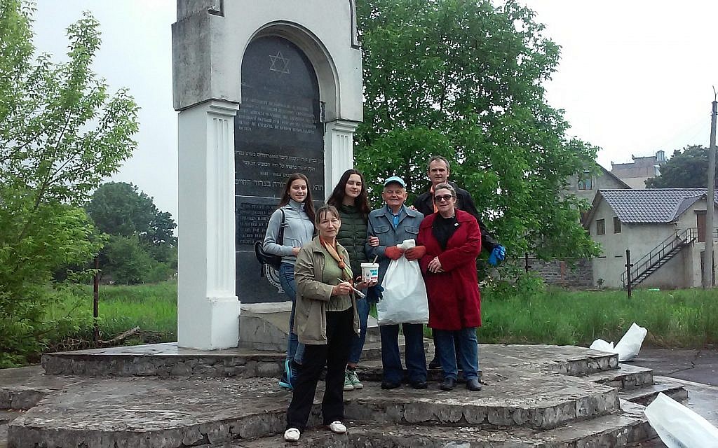 Kalush Gymnasim teacher Natalia Zubrytska, who ran to paint over a swastika,  front center with paintbrush. (Kalush Gymnasium)