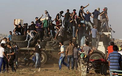 In this September 21, 2018 file photo, protesters arrive on a truck with tires to burn near the the fence of Gaza Strip border with Israel during a protest. (AP Photo/Adel Hana, File)