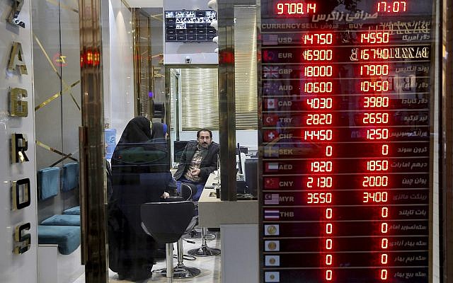 Customers speak with a money changer at his shop in downtown Tehran, Iran, November 5, 2018. (AP Photo/Ebrahim Noroozi) Customers speak with a money changer at his shop in downtown Tehran, Iran, November 5, 2018. (AP Photo/Ebrahim Noroozi)
