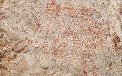 This composite image from the book "Borneo, Memory of the Caves" shows the world's oldest figurative artwork dated to a minimum of 40,000 years, in a limestone cave in the Indonesian part of the island of Borneo. (Luc-Henri age/kalimanthrope.com via AP)