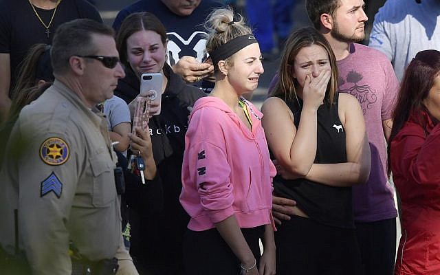 People cry as a law enforcement motorcade escorts the body of Ventura County Sheriff's Department Sgt. Ron Helus from the Los Robles Regional Medical Center Thursday, Nov. 8, 2018, in Thousand Oaks, Calif., after a gunman opened fire Wednesday evening inside a country music bar, killing multiple people including Helus. (AP Photo/Mark J. Terrill) People cry as a law enforcement motorcade escorts the body of Ventura County Sheriff's Department Sgt. Ron Helus from the Los Robles Regional Medical Center Thursday, Nov. 8, 2018, in Thousand Oaks, Calif., after a gunman opened fire Wednesday evening inside a country music bar, killing multiple people including Helus. (AP Photo/Mark J. Terrill)