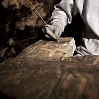 An archaeologists works on an artifact inside a tomb, at an ancient necropolis near Egypt's famed pyramids in Saqqara, Giza, Egypt, November 10, 2018. (Nariman El-Mofty/AP)