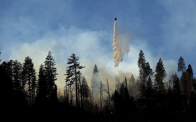 A helicopter drops water while battling the Camp Fire burning near Pulga, Calif., on Sunday, Nov. 11, 2018. (AP Photo/Noah Berger) A helicopter drops water while battling the Camp Fire burning near Pulga, Calif., on Sunday, Nov. 11, 2018. (AP Photo/Noah Berger)