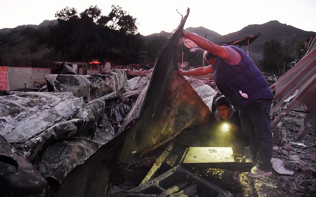 Illustrative: residents search for belongings at their destroyed home on November 11, 2018, following devastating wildfires in the area in Agoura Hills, California. (AP Photo/Chris Pizzello)