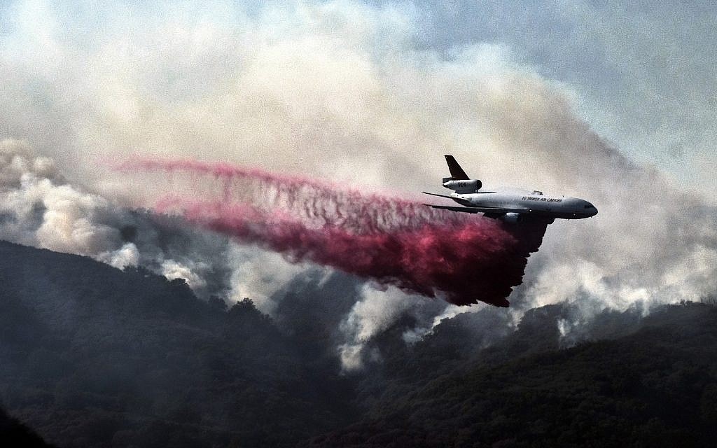 A firefighting DC-10 makes a fire retardant drop over a wildfire in the mountains near Malibu Canyon Road in Malibu, California, on November 11, 2018. (AP Photo/Richard Vogel)