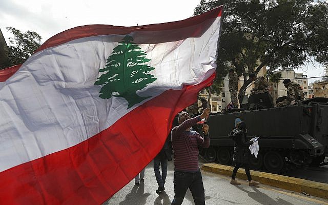 A protester waves a Lebanese flag during a protest against corruption and the failure of long-serving politicians to form a government, in Beirut, Lebanon, Thursday, Nov. 22, 2018. Lebanon is marking 75 years of independence with a military parade Thursday in Beirut, but many anxious Lebanese feel they have little to celebrate: the country's corruption-plagued economy is dangerously close to collapse and political bickering over shares in a new Cabinet is threatening to scuttle pledges worth $11 billion by international donors. (AP Photo/Hussein Malla) A protester waves a Lebanese flag during a protest against corruption and the failure of long-serving politicians to form a government, in Beirut, Lebanon, Thursday, Nov. 22, 2018. Lebanon is marking 75 years of independence with a military parade Thursday in Beirut, but many anxious Lebanese feel they have little to celebrate: the country's corruption-plagued economy is dangerously close to collapse and political bickering over shares in a new Cabinet is threatening to scuttle pledges worth $11 billion by international donors. (AP Photo/Hussein Malla)