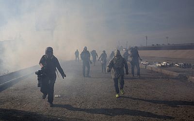 Migrants run from tear gas launched by US agents on the Mexico-US border, November 25, 2018. (AP Photo/Rodrigo Abd)