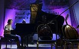 In this Sunday, Nov. 25, 2018. file photo, Japanese pianist Kaoru Imahigashi plays the piano during a concert to mark the debut of Gaza's only grand piano after it was rescued from conflict, at a theater nestled in the Palestinian Red Crescent Society's building in Gaza City. Palestinian businessman Saed Herzallah has seized Gaza Strip's only grand piano, claiming he owns the instrument, just days after it made its public debut. (AP Photo/Adel Hana, File)