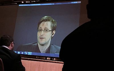 In this Feb, 17, 2016 file photo, former National Security Agency contractor Edward Snowden, center speaks via video conference to people in the Johns Hopkins University auditorium, in Baltimore. G(AP Photo/Juliet Linderman, File)