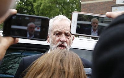 People take photos of Britain's Labour Party leader Jeremy Corbyn during a visit to the scene of the massive fire in Grenfell Tower, in rear, in London, Thursday, June 15, 2017. (AP/Alastair Grant)