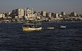 Palestinian fishing boats sail into the waters of the Mediterranean Sea in Gaza City, Monday, July 9, 2018, with buildings of Gaza City seen in background. (AP Photo/Adel Hana)
