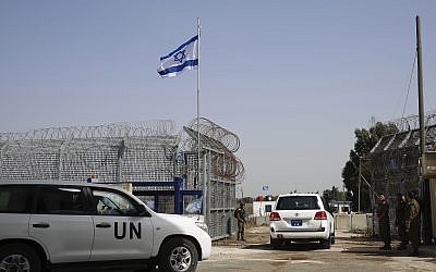 An Israeli soldier opens the border gates as a UN vehicle enters Syria at the Quneitra crossing in the Golan Heights, Monday, October 15, 2018. (AP Photo/Ariel Schalit)