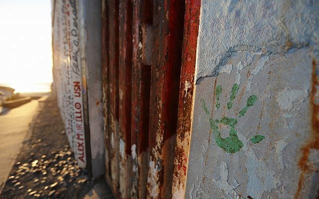 A hand print in honor of migrants that have been killed or are missing is seen on a border wall structure separating Tijuana, Mexico from San Diego, in Tijuana on October 16, 2018. (AP Photo/Gregory Bull) A hand print in honor of migrants that have been killed or are missing is seen on a border wall structure separating Tijuana, Mexico from San Diego, in Tijuana on October 16, 2018. (AP Photo/Gregory Bull)