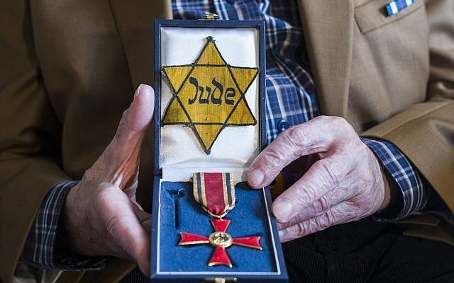 Walter Frankenstein, witness of the November 9, 1938 terror against Jews in Berlin and one of the few survivors of Auerbach'sches Waisenhaus orphanage shows a box with the Yellow badge the Nazis forced him to wear and with the Germany's Federal Cross of Merit he got in 2014, during an interview with the Associated Press in Berlin, November 5, 2018. (Markus Schreiber/AP)