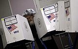 An Orthodox Jewish man fills out his ballot papers at a polling center on Tuesday, Nov. 6, 2018, in Brooklyn borough of New York. (AP Photo/Wong Maye-E)