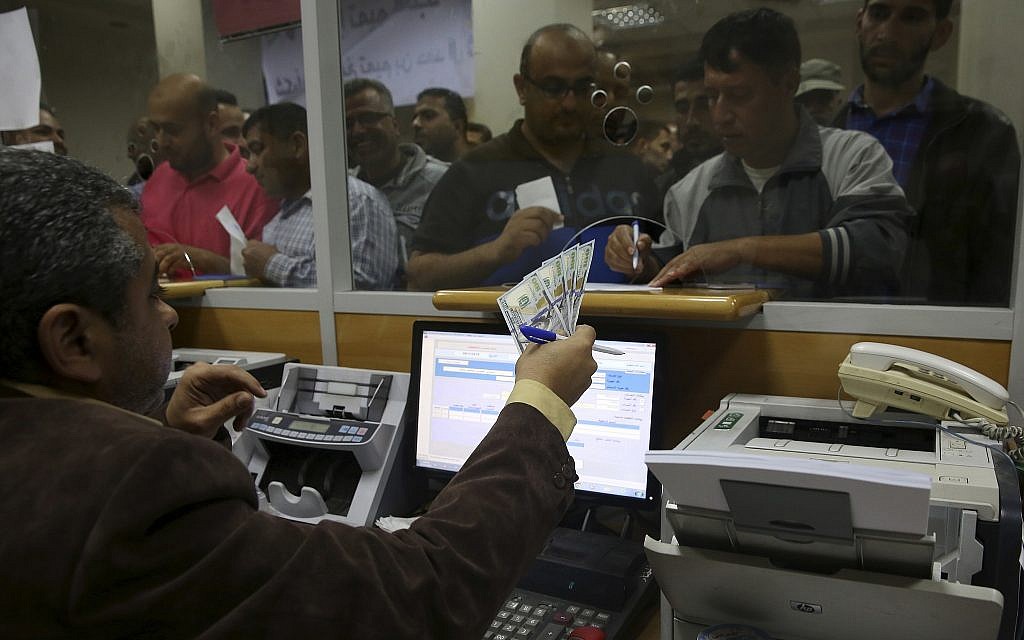 A Palestinian Hamas government employee signs to receive 60 percent of their long-overdue salary while others wait in the queue, at the main Gaza Post Office, in Gaza City, Friday, November 9, 2018. (AP/Adel Hana)