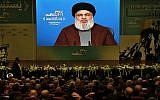 Supporters of the Iranian-backed Hezbollah terror group listen to a speech by leader Hassan Nasrallah, via a video link, during a rally marking Hezbollah Martyr's Day, in a southern suburb of Beirut, Lebanon, November 10, 2018. (AP Photo/Bilal Hussein)