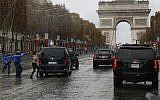 French police officers run after a topless protester who rushes the motorcade of US President Donald Trump on the Champs Elysees in Paris, November 11, 2018 (AP Photo/Jacquelyn Martin)