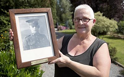 Resident Marilyn Lahaeu holds up a photo of World War I soldier Pvt. George Lawrence Price, who was killed in the Belgian village of Ville-sur-Haine, in 1918, near her home in Ville-sur-Haine, Belgium, Sunday, Aug. 3, 2014. (AP Photo/Virginia Mayo)