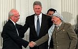 US President Bill Clinton gestures toward Prime Minister Yitzhak Rabin, left, and PLO leader Yasser Arafat shaking hands in the East Room of the White House, September 28, 1995. Egyptian President Hosni Mubarak looks on behind Arafat. (AP Photo/Doug Mills)