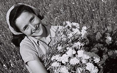 A girl with a bunch of carnations in a field at moshav Mishmar Hasharon (GPO, Public Domain/Wikimedia Commons)