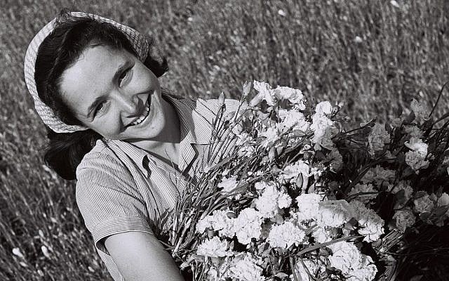 A girl with a bunch of carnations in a field at moshav Mishmar Hasharon (GPO, Public Domain/Wikimedia Commons)