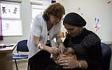Illustrative: An child is vaccinated at a Tipat Halav clinic in Jerusalem on August 18, 2013. (Yonatan Sindel/Flash90)