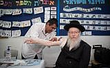 Deputy Health Minister Yaakov Litzman gets his flu shot at the Efrata Elementary School in Jerusalem on October 26, 2017. (Hadas Parush/Flash90)