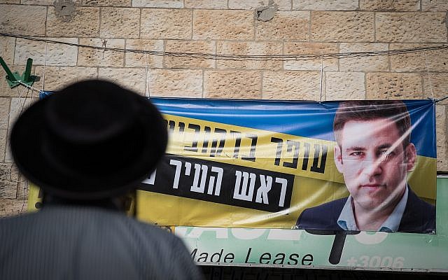 An ultra-Orthodox man stands outside a campaign office for Jerusalem mayoral candidate Ofer Berkovitch in Jerusalem on November 8, 2018. (Hadas Parush/Flash90) An ultra-Orthodox man stands outside a campaign office for Jerusalem mayoral candidate Ofer Berkovitch in Jerusalem on November 8, 2018. (Hadas Parush/Flash90)
