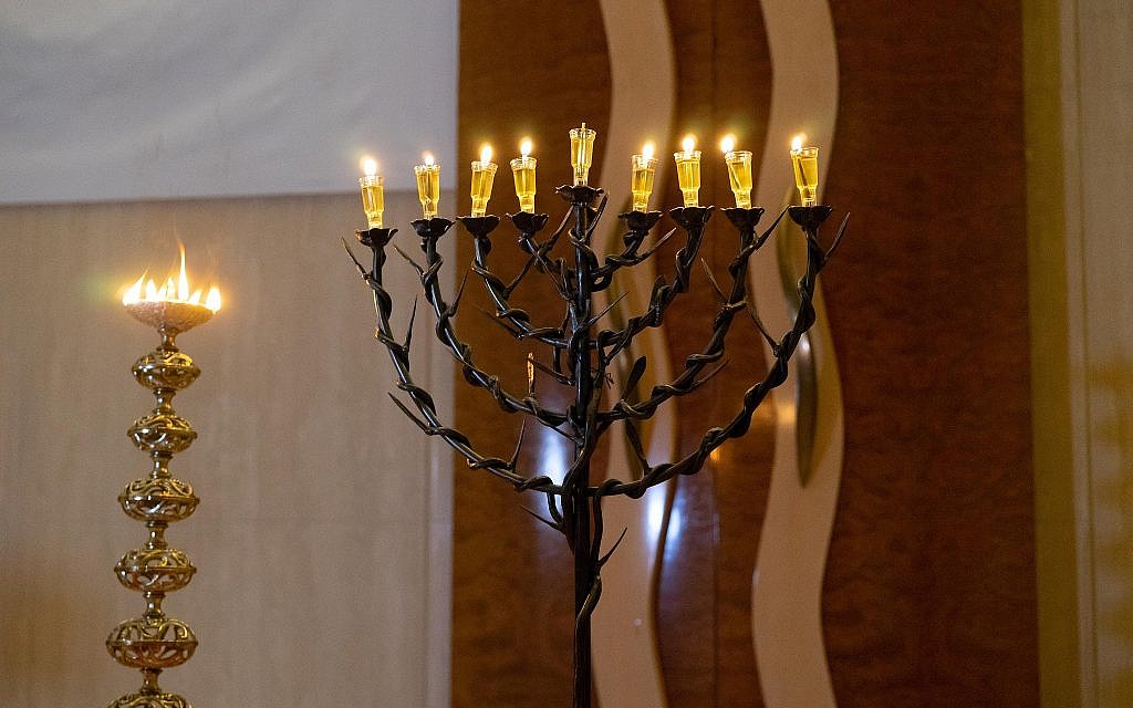 A Diwali diya and Hanukkah menorah shine side by side at the Hindu-Jewish Festival of Lights at Temple Beth-El in Northbrook, Illinois, Sunday, November 18, 2018. (Ronit Bezalel/ Times of Israel)