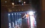 Screen capture from video of firemen rescuing a driver who became trapped in his car in a Haifa underpass, November 24, 2018.