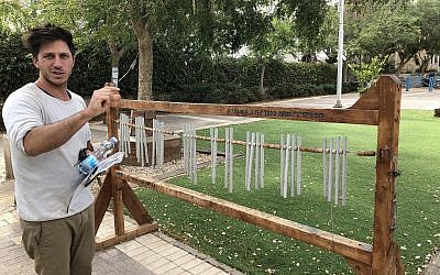 The oversized xylophone that was made and placed in a public space by Matan Saad, pictured here, along with other members of Beersheva's placemaking volunteers, and then broadened into a playground by the city, as part of the efforts to change the look and feel of the southern city (Jessica Steinberg/Times of Israel)