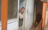 Zabolon Simantov kisses the mezuzah on his way out the front door of his home at the synagogue compound in Kabul, in an undated photo. (Ezzatullah Mehrdad/Times of Israel)