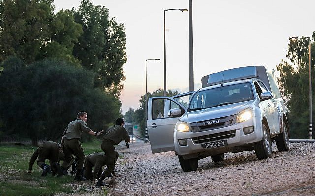 Israeli soldiers lying on the side of the road in southern Israel as they take cover from incoming rockets fired from Gaza into Israel, November 12, 2018. (Hadas Parush/Flash90) Israeli soldiers lying on the side of the road in southern Israel as they take cover from incoming rockets fired from Gaza into Israel, November 12, 2018. (Hadas Parush/Flash90)