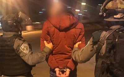 The Palestinian suspected of carrying out a a stabbing attack in the central West Bank is taken into custody by Border Police officers after turning himself in at the Rachel checkpoint on November 20, 2018. (Border Police)