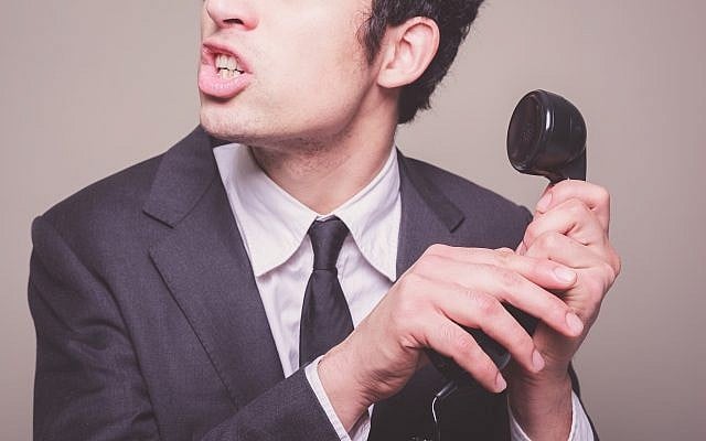 Illustrative photo of a phone scammer (Photo credit: lolostock/iStock)