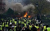 Demonstrators gather in front of a burning car during a protest of Yellow vests (Gilets jaunes) against rising oil prices and living costs, on December 1, 2018 in Paris. (Geoffroy VAN DER HASSELT / AFP)